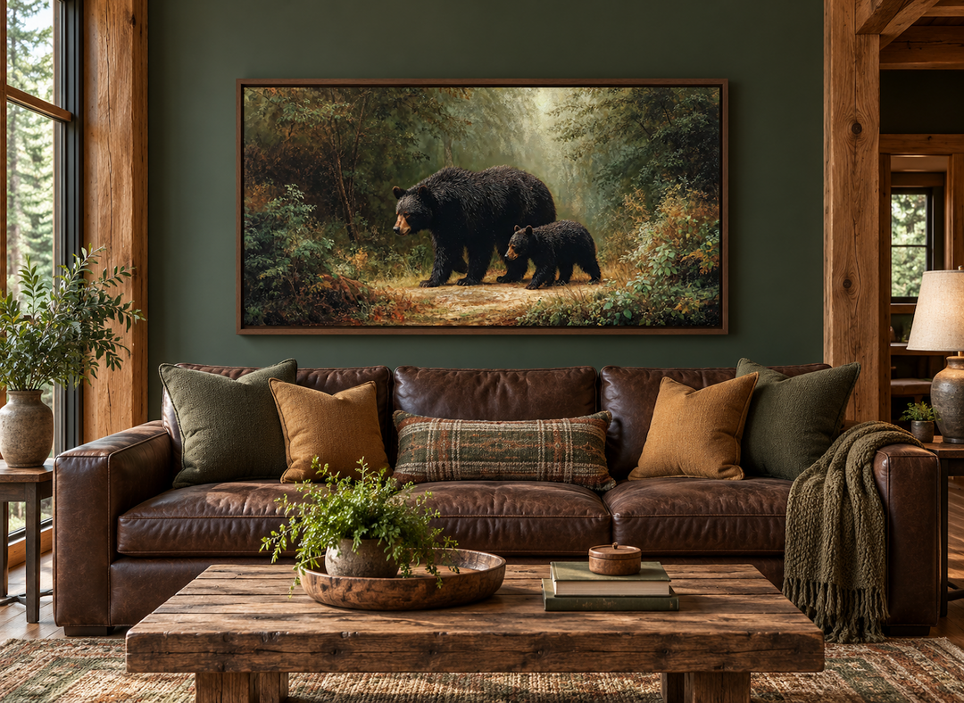 Black mama bear and cub walking in a forest canvas wall art above a brown leather sofa.