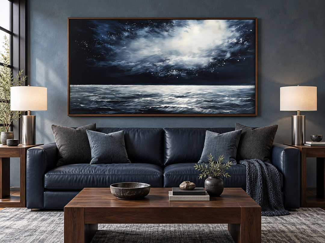 Dark horizontal starry night ocean seascape framed canvas wall art above a navy leather sofa.