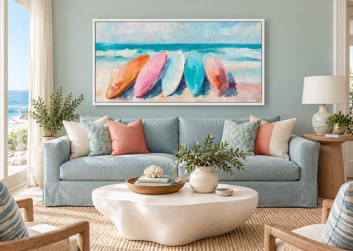 Coastal canvas wall art with pastel surfboards above a blue sofa in a beach-themed living room.