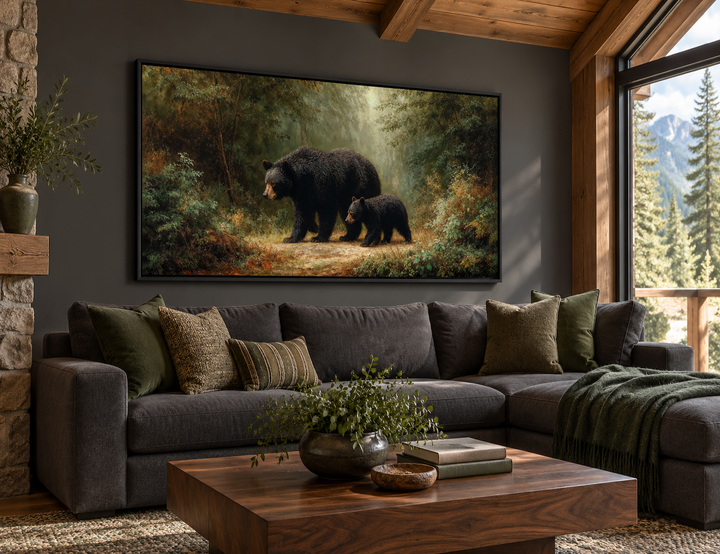 Black mama bear and cub walking in a forest canvas wall art above a charcoal sectional sofa.