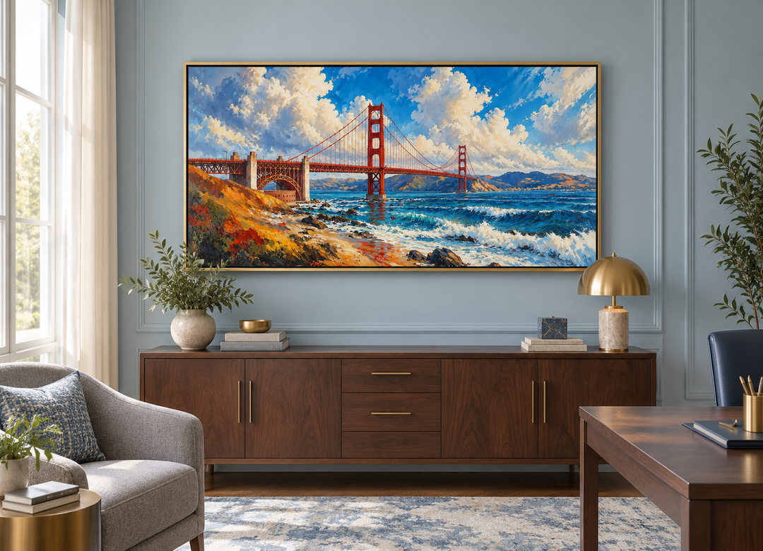 Framed oil painting of the Golden Gate Bridge above a wooden sideboard in a modern office.