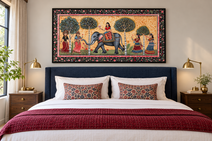 Framed Madhubani style painting of an elephant and women hanging above a bed in a bedroom.