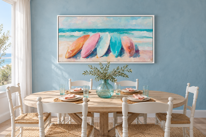 Coastal canvas wall art with pastel surfboards above a dining table in a blue beach house room.