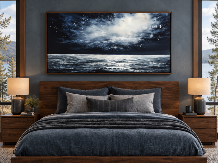 Dark horizontal starry night ocean seascape framed canvas wall art hanging above a bed.