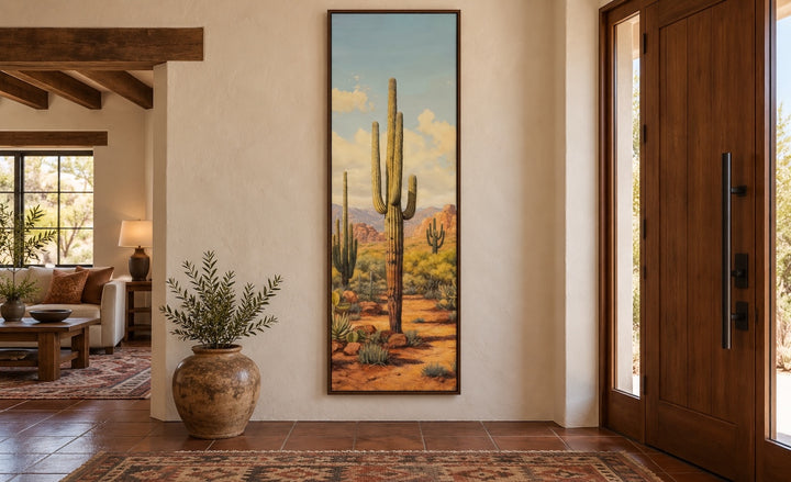 Tall vertical saguaro cactus canvas wall art in a narrow walnut frame in a Southwestern entryway.