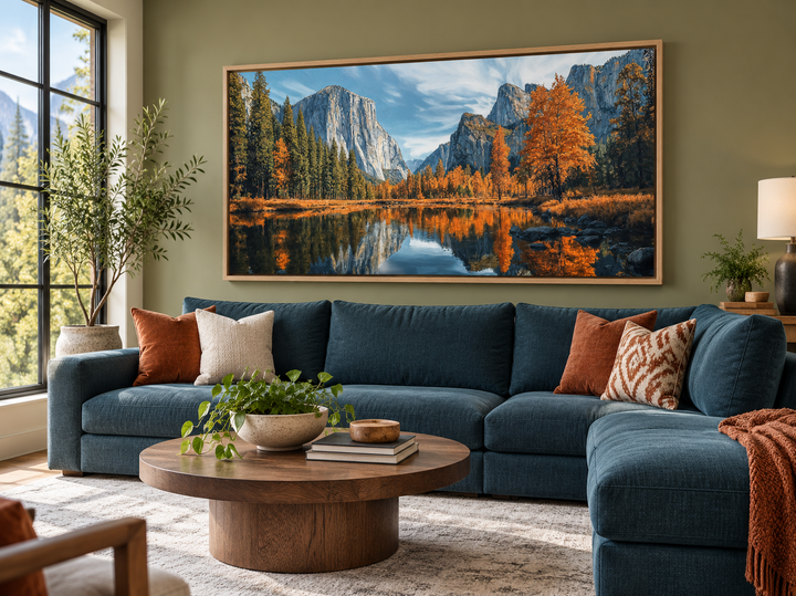 Framed canvas wall art of Yosemite National Park in autumn hanging above a teal sectional sofa.