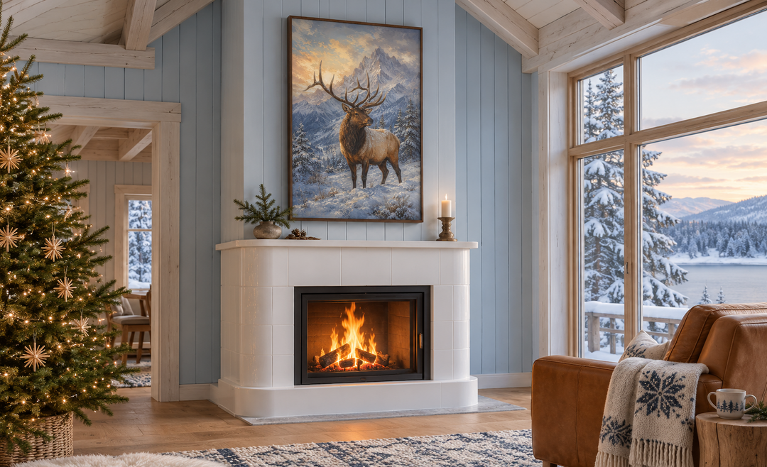 Elk in Snowy Mountains Framed Canvas Wall Art hanging above a white fireplace in a winter cabin.