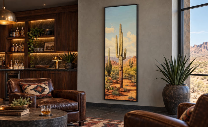 Tall vertical saguaro cactus canvas wall art in a black frame on a neutral wall in a desert-style room