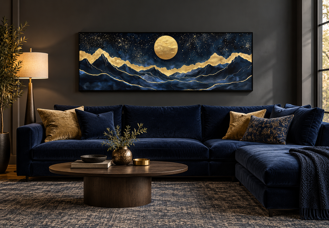Panoramic gold and navy mountain landscape canvas print with a full moon above a blue velvet sofa.