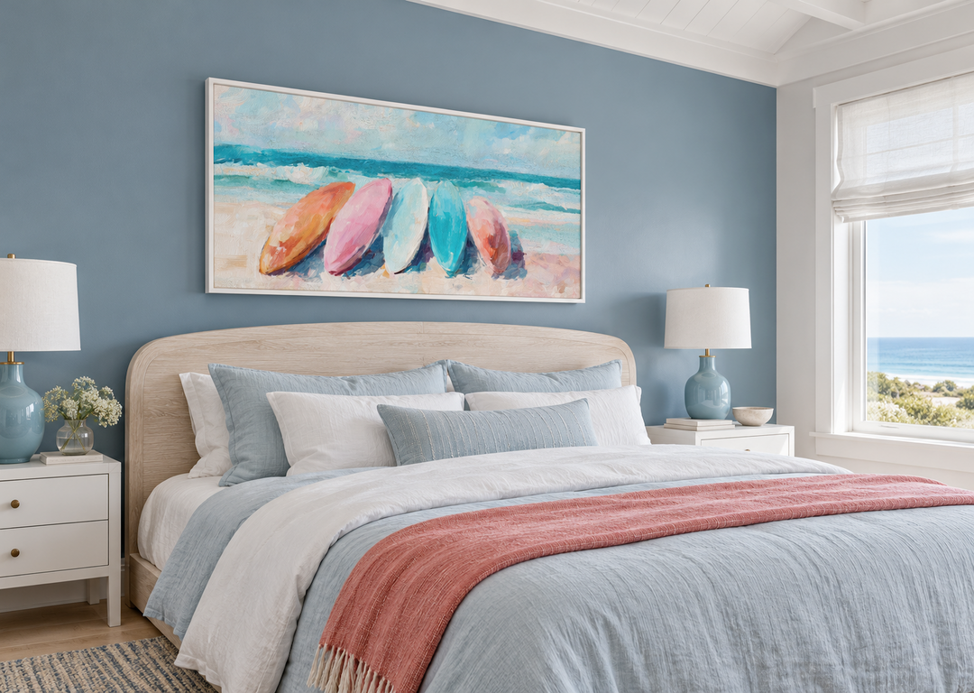Coastal canvas wall art with pastel surfboards above a bed in a blue beach house bedroom.