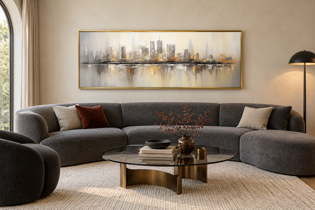 Gold and silver abstract Chicago skyline horizontal wall art in a gold frame above a grey sofa.