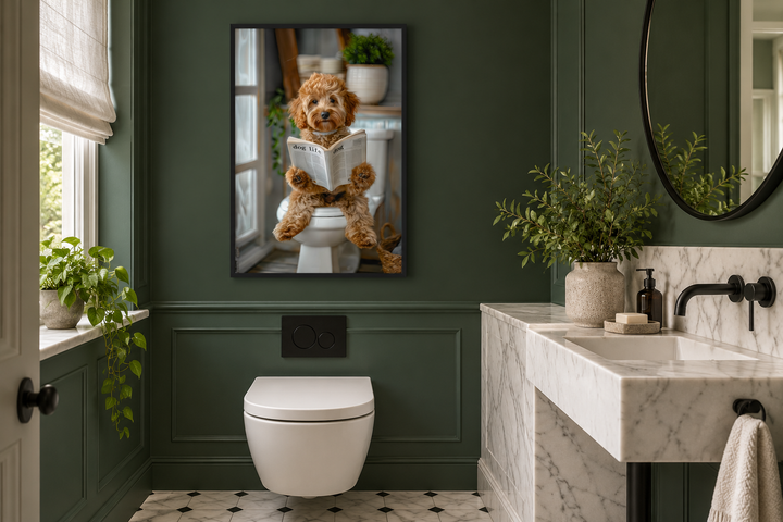 Framed wall art of a Cockapoo dog sitting on a toilet reading a newspaper in a green bathroom.