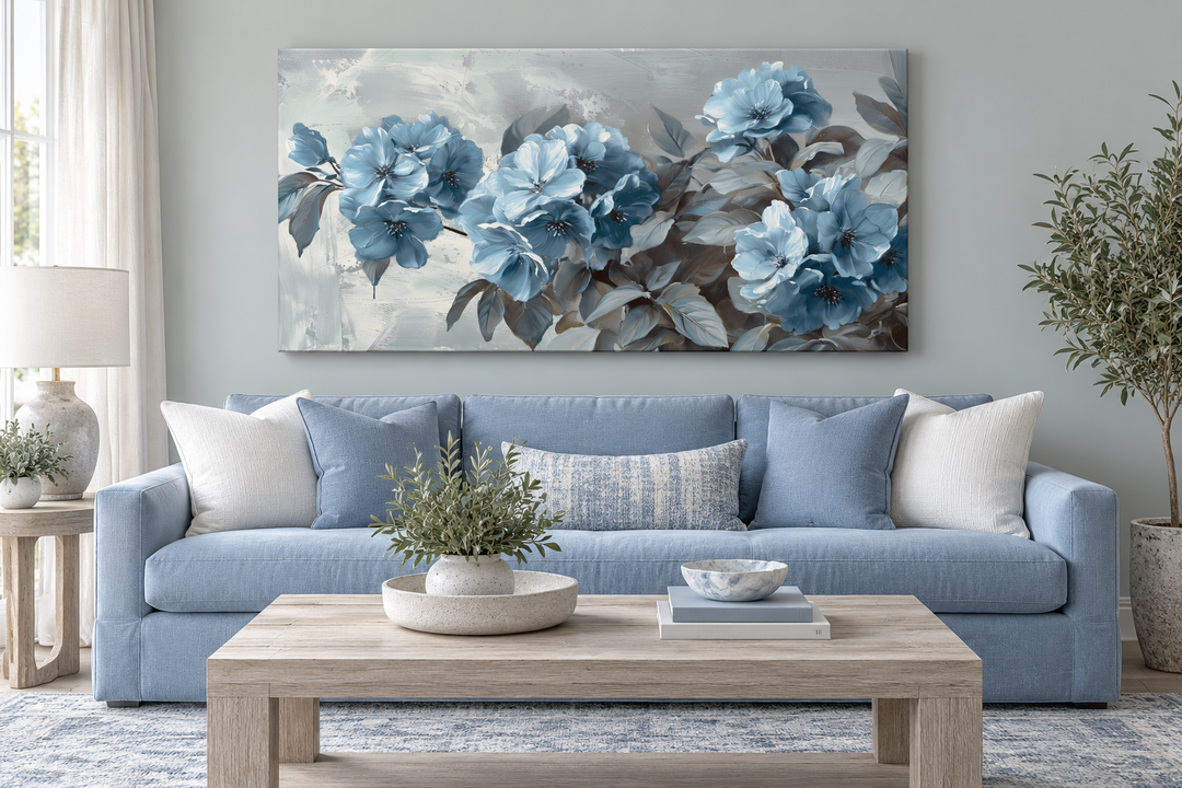 Large abstract light blue floral canvas wall art hanging above a blue sofa in a modern living room.