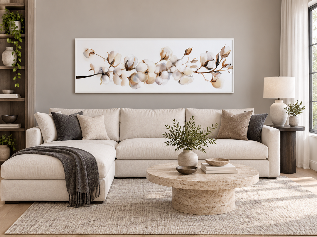Long horizontal canvas wall art featuring neutral cotton plants above a beige sectional sofa.