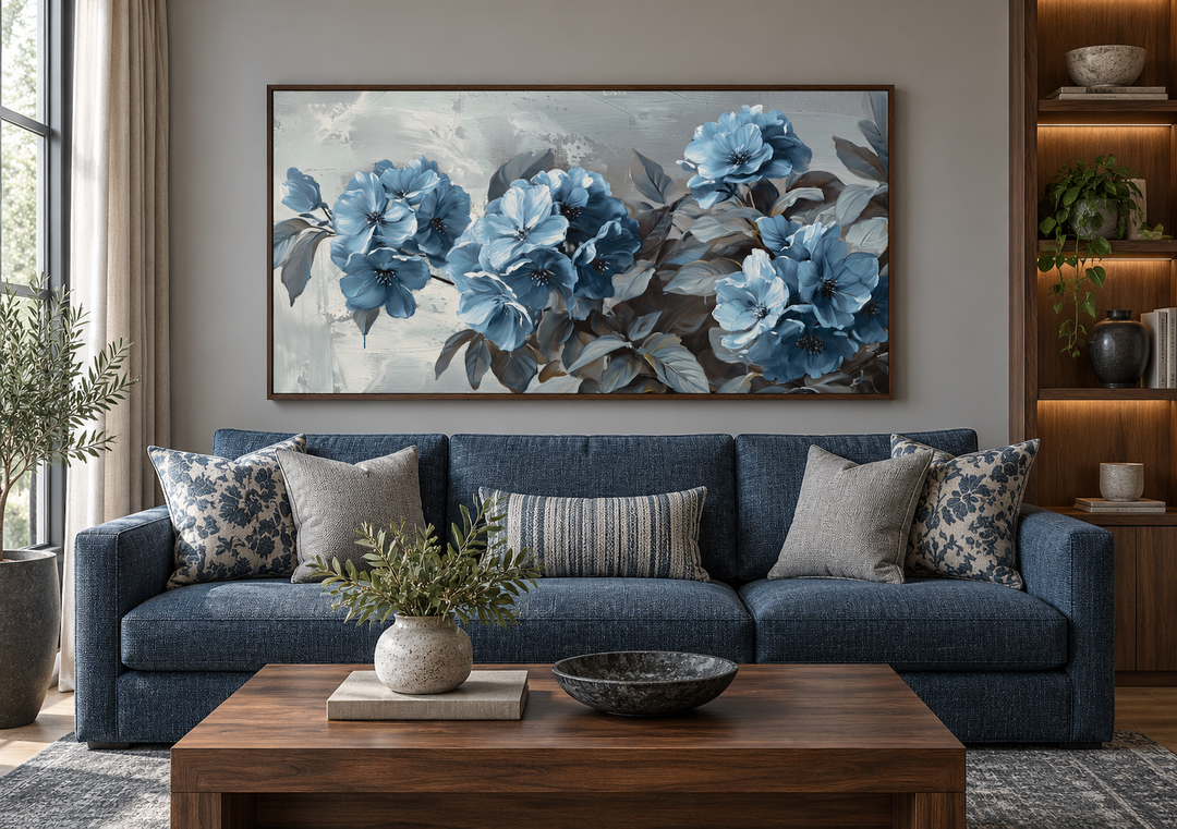 Large horizontal canvas print of abstract light blue flowers on a grey background in a living room.