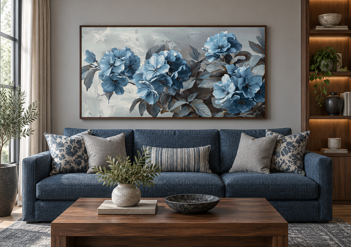 Large horizontal canvas print of abstract light blue flowers on a grey background in a living room.