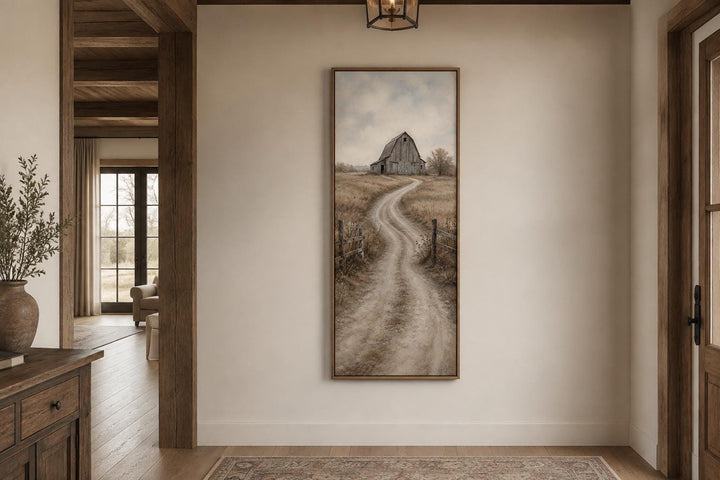 Tall narrow farmhouse wall art of a weathered barn and winding dirt road through golden fields.