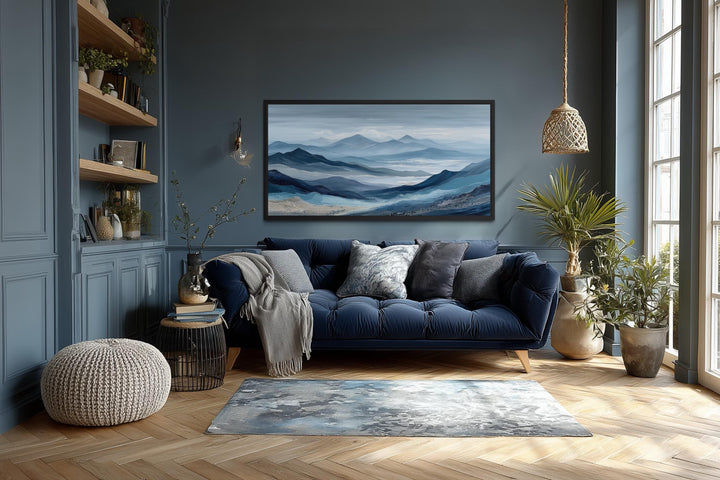 Blue mountain serene nature landscape canvas wall art above a navy sofa in a dark blue living room.