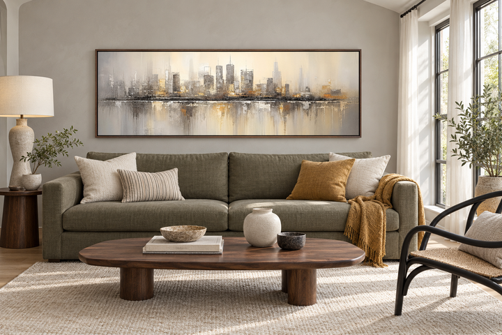 Gold and silver abstract Chicago skyline horizontal wall art in a walnut frame above a green sofa.