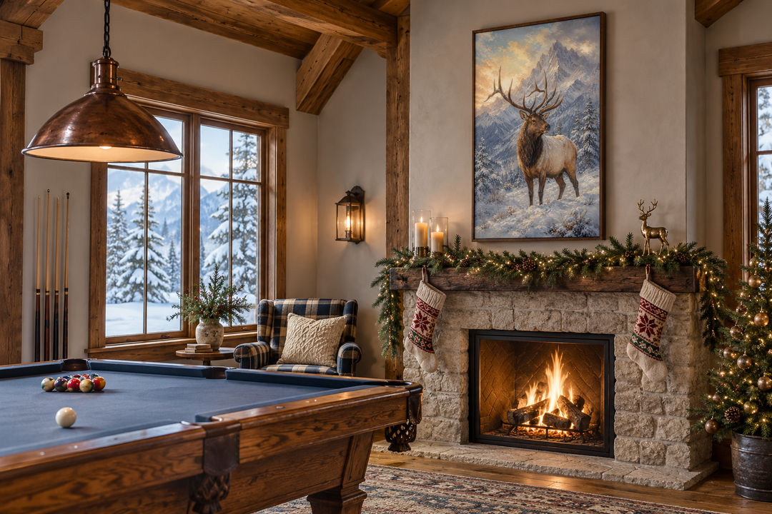 Elk in Snowy Mountains framed canvas wall art hanging above a stone fireplace in a cozy cabin.