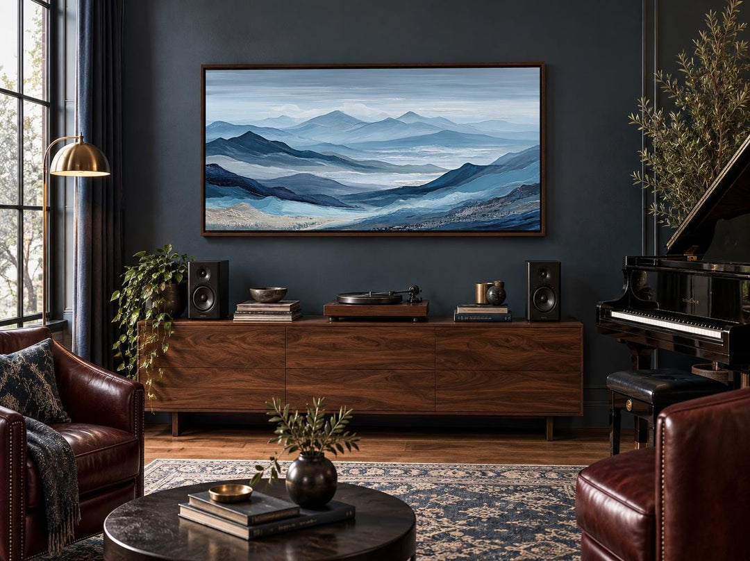 Blue mountain landscape canvas wall art with misty peaks in a dark blue living room.