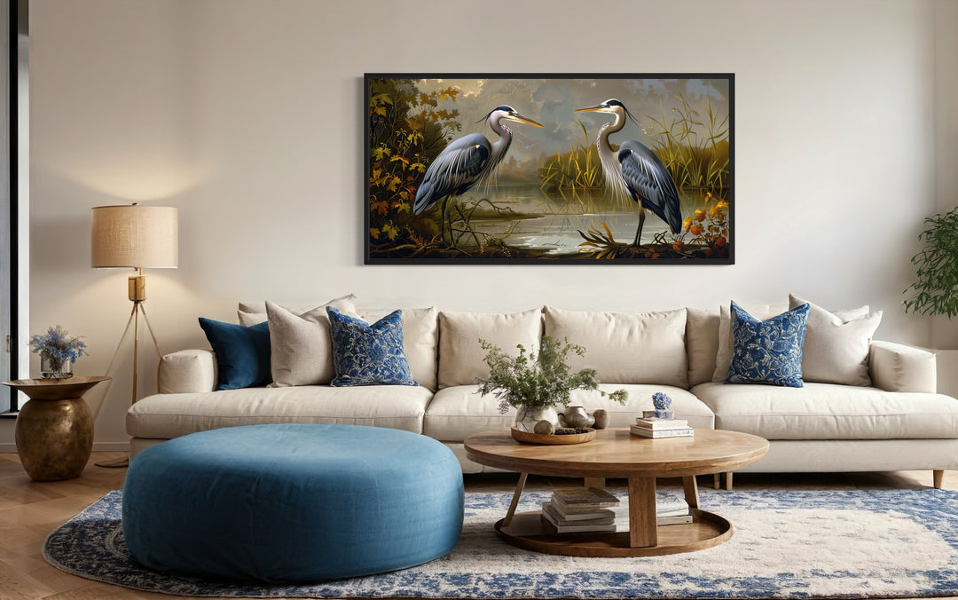 Two Blue Herons On The Lake Framed Canvas Wall Art above beige couch