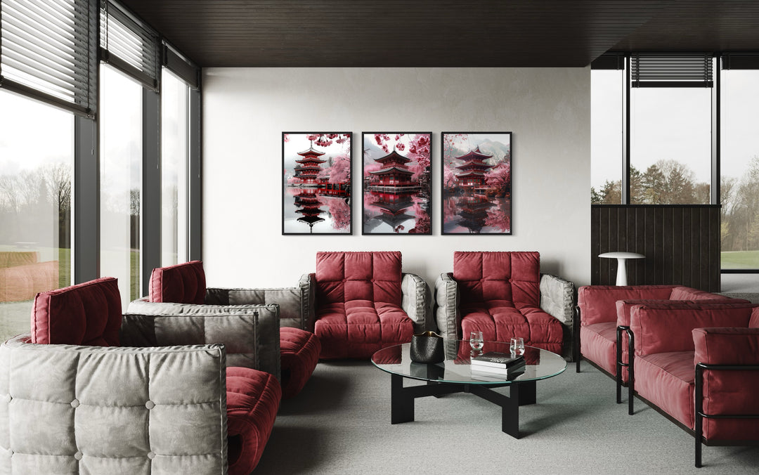 Set Of Three Japanese Pagoda and Cherry Blossom Wall Art in a living room filled with red couches and a glass table