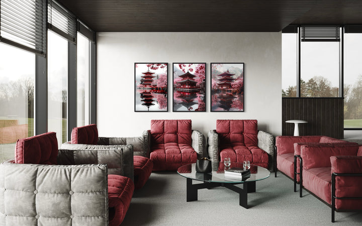 Set Of Three Japanese Pagoda and Cherry Blossom Wall Art in a living room filled with red couches and a glass table