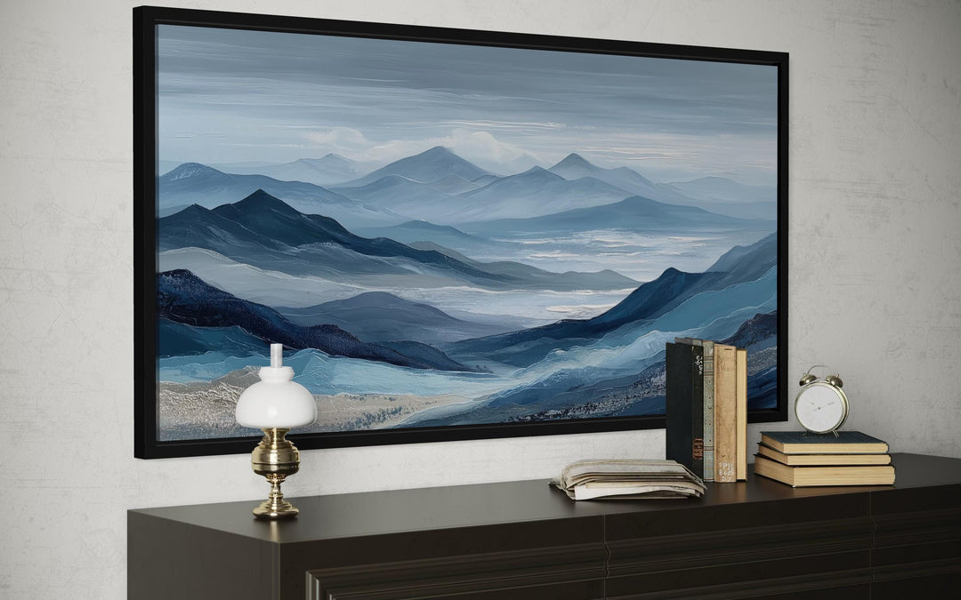 Blue mountain serene nature landscape canvas wall art in a black frame above a dark wood console.