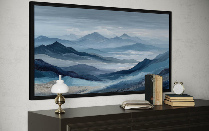 Blue mountain serene nature landscape canvas wall art in a black frame above a dark wood console.