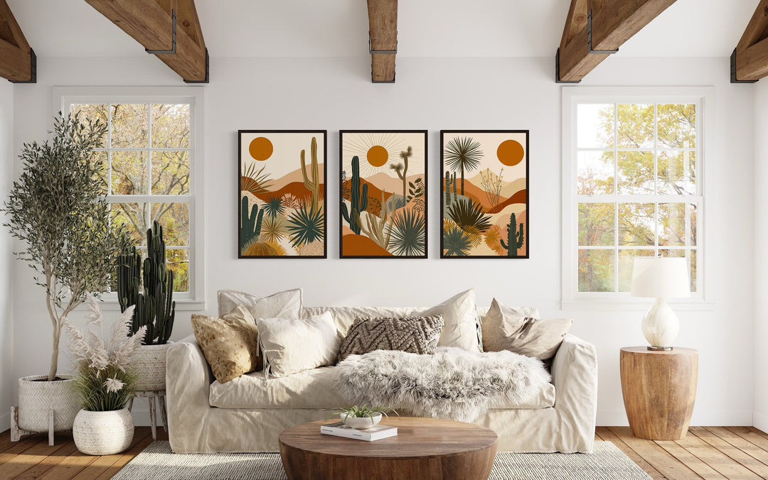 3-piece mid-century modern desert cactus and sun framed canvas wall art set above a white sofa.
