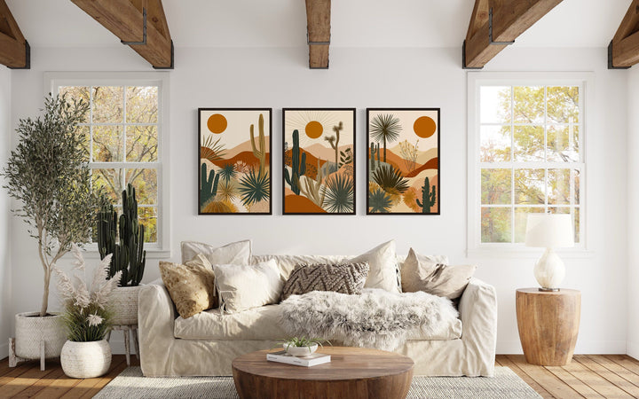 3-piece mid-century modern desert cactus and sun framed canvas wall art set above a white sofa.