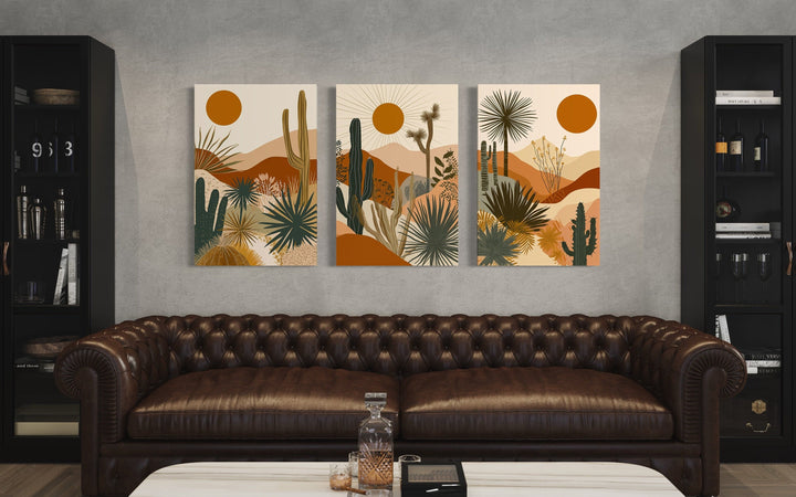 3-piece mid-century modern desert cactus and sun framed canvas wall art set above a leather sofa.