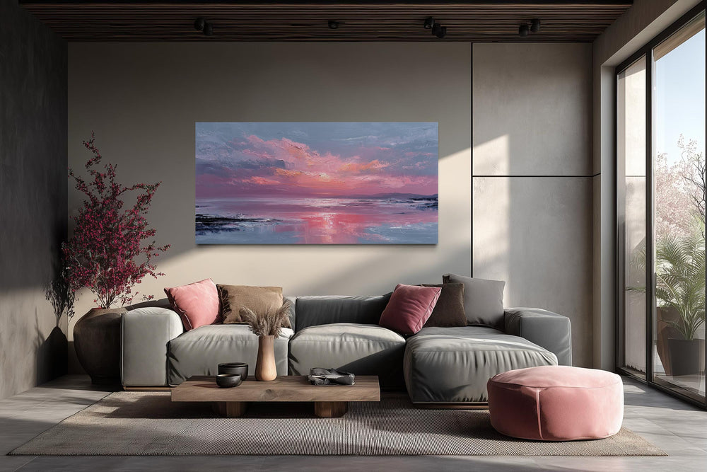 Blush pink ocean sunset coastal canvas wall art displayed above a modern grey sectional sofa.