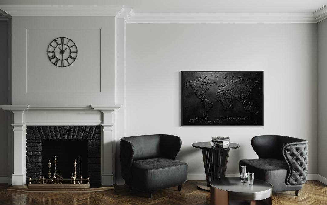 Black World Map Framed Canvas Wall Art in a living room with two chairs and a fireplace