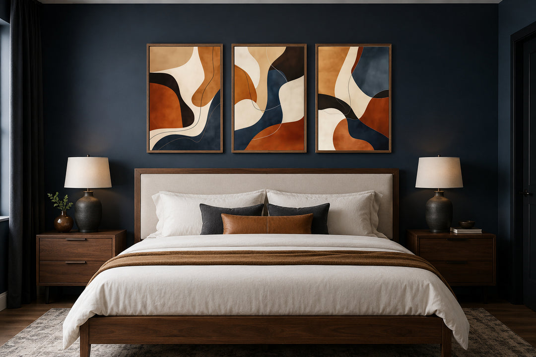 3 piece mid-century modern abstract wall art in earth tones, brown, cream, and navy above a bed.