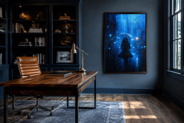 Woman silhouette walking in rain with umbrella canvas wall art in a dark blue home office.
