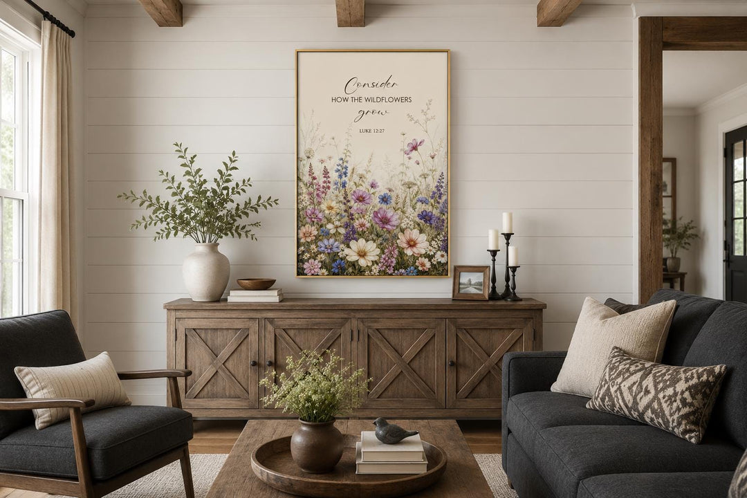 Wildflower watercolor wall art with Luke 12:27 scripture verse in a gold frame above a sideboard.