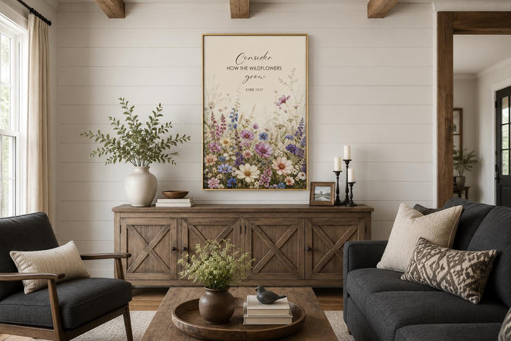 Wildflower watercolor wall art with Luke 12:27 scripture verse in a gold frame above a sideboard.