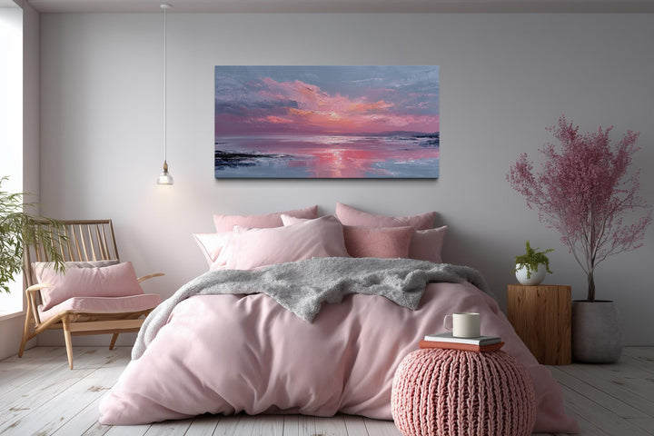 Blush pink ocean sunset coastal canvas wall art displayed above a bed in a serene bedroom.