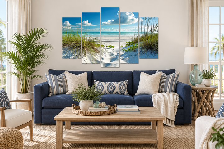 5-piece canvas wall art of a white sand beach with sea grass dunes above a blue sofa.