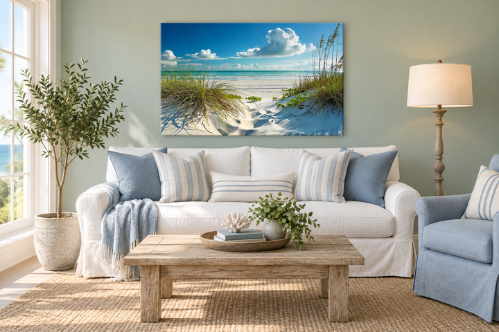 Large canvas wall art of a white sand beach with sea grass dunes above a white sofa.