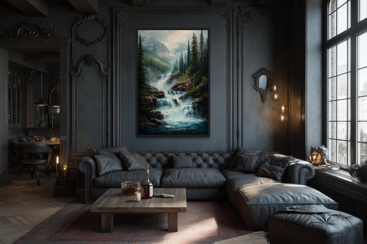 Mountain waterfall vertical canvas wall art in a dark wood frame above a black leather sofa.