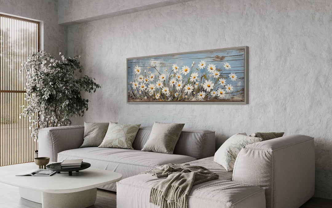 a living room with a white couch and a painting on the wall