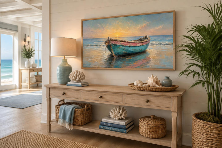Weathered teal and pink rowboat painting in a gold frame above a wooden console table.