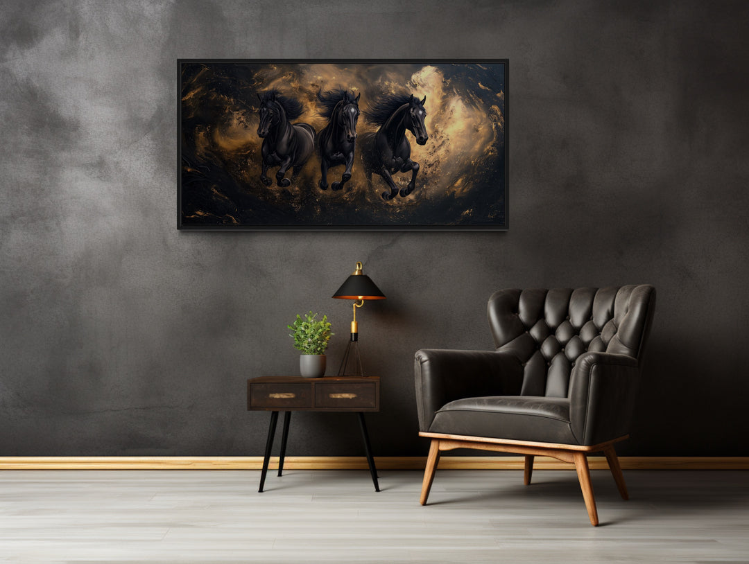 Three Running Stallions On Black Gold Background Framed Canvas Wall Art in a room with a chair