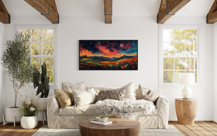 Starry Night Sky Over Wildflower Fields and Mountains Framed Canvas Wall Art in living room above beige couch