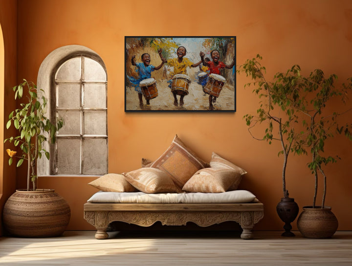 Happy African Kids Playing Drums Framed Canvas Wall Art in a living room with a couch and a painting on the wall