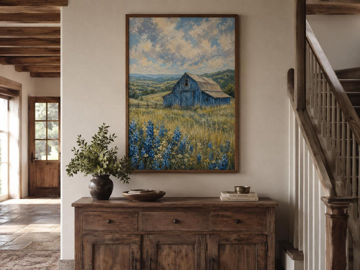 Vertical farmhouse canvas art of a blue barn in a bluebonnet field under a cloudy sky.