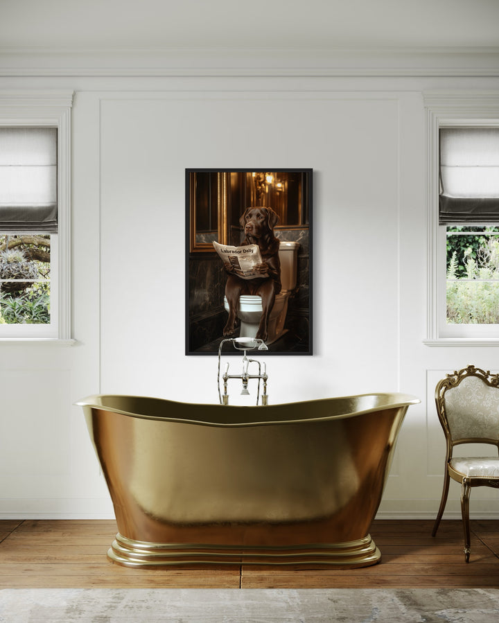 Chocolate Brown Labrador Retriever On Toilet Reading Newspaper Framed Canvas Wall Art in a bathroom with a gold bathtub and a chair